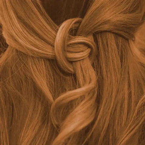Nahaufnahme von goldenbraunen Haaren mit Knotenfrisur, warm goldbraune Haarfarbe