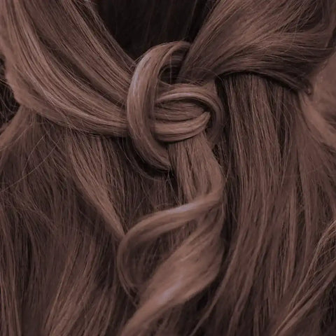 Lockige mittelbraune Haare kunstvoll zu einem Knoten gestylt, Haarfarbe natürlich