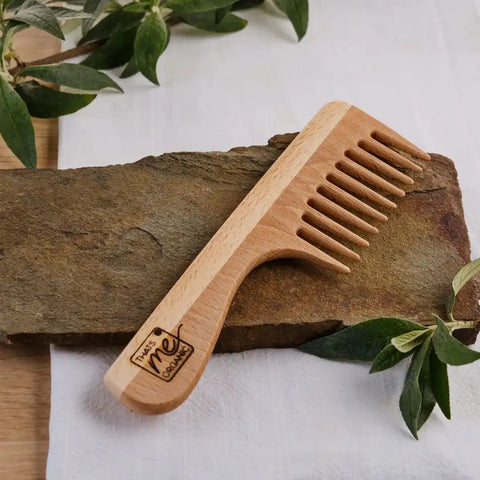 Holzkamm aus Buchenholz mit breiten Zähnen auf Steinplatte, Naturkosmetik Accessoire