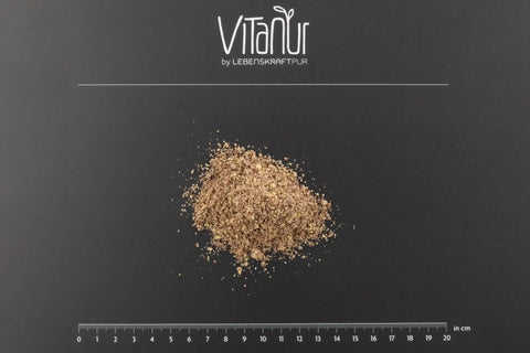 Bio braunes Leinsamenmehl gemahlen auf schwarzem Hintergrund mit Lineal, Vitanur Logo