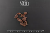 Bio Schokobohne Stücke auf schwarzem Hintergrund mit Vitanur Logo und Zentimeterskala