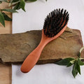 Holzbürste mit Naturborsten auf Steinplatte, Naturkosmetik Produkt Präsentation