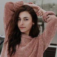 Frau mit langen braunen Haaren in rosa Pullover, Porträt draußen, modisch, selbstbewusst